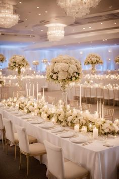 a long table is set with white flowers and candles for an elegant wedding reception at the four seasons resort