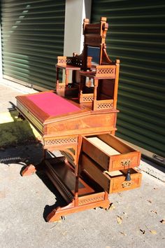 an old wooden desk with drawers sitting on the sidewalk