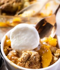 a close up of a bowl of food with fruit and ice cream on top,