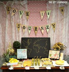 a table topped with lots of food next to a sign that says love is a journey