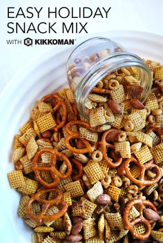 a white bowl filled with cheetos and pretzels next to a glass jar