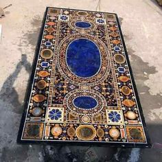 an intricately designed table sitting on the ground