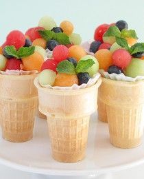 four ice cream cones filled with fruit on top of a white plate and the words fun & healthy snacks for kids