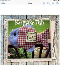 a fish stuffed animal sitting on top of a wooden bench with the words keepake fish