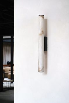 a white wall with a black pipe on it