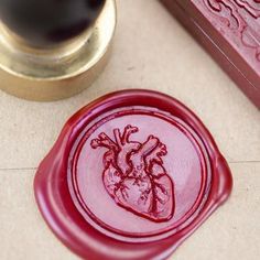 a red wax stamp with a heart on it