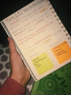 a hand holding a notebook with notes on it