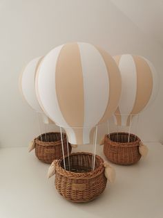 three hot air balloons sitting in baskets on a table