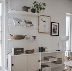 a white room with shelves and pictures on the wall