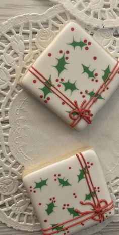 two decorated cookies sitting on top of a white doily covered table next to each other