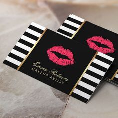 two black and white striped business cards with pink lipstick on the front one has gold trim