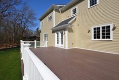 a house with a white fence and brown deck