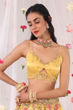 Mustard blouse in gajji satin base with floral embroidered motifs in cutdana and sequins.
Component: 1
Pattern: Embroidered
Type Of Work: Floral Motifs
Neckline: V-neck
Sleeve Type: Sleeveless
Fabric: Semi Crepe, Gajji Satin
Color: Yellow
Other Details: 
Cut-out details
Note: The lehenga worn by the model is not for sale
Occasion: Mehendi and Haldi - Aza Fashions Mustard Blouse, Sari Blouse, Blouse For Women, Satin Color, Indian Fashion Designers, Pernia Pop Up Shop, Sequins Embroidery, Blouse Online, V Neck Blouse