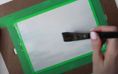 a person is using a pair of scissors to cut out the bottom part of a piece of paper