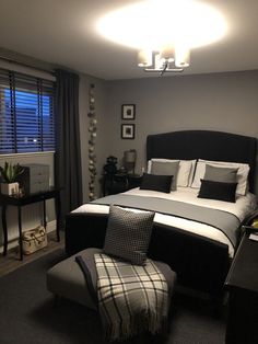 a bedroom with a bed, chair and window in the corner is lit by lights