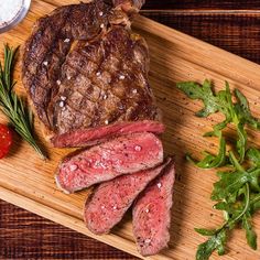 steak and vegetables on a cutting board ready to be cut into pieces with salt and pepper