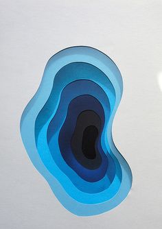 an abstract piece of paper with blue shapes on the bottom and black circles in the middle