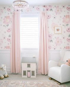 a baby's room with floral wallpaper and pink curtains