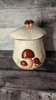 a ceramic jar with two mushrooms on it