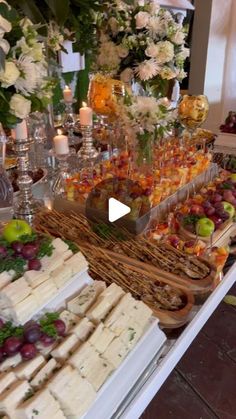 a buffet table filled with lots of food and flowers on top of each other,