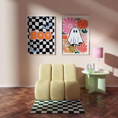 two paintings hang on the wall above a checkered rug in a room with wooden flooring