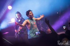 a man standing on top of a stage holding his arms out in front of him