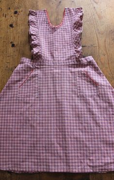 FRENCH VINTAGE 50's, lovely pinafore dress / apron dress, pink and blue checkered cotton fabric, red trim edges, wide open sleeves, two patch pockets, buttoned down the waist ( glass buttons ). Estimated size 9 years : Length 32,3" New old stock ( washed once ) In case of multiple purchases, if you want an accurate shipping estimation, please contact me ; I do always refund overcharged shipping from 1 Euro overpaid ! Thank you for your visit Pink Cotton School Dress, Pink Cotton Dress For School, Vintage Cotton Plaid Dress, Sleeveless Cotton Plaid Dress With Ruffles, Retro Gingham Plaid Cotton Dress, Vintage Sleeveless Plaid Cotton Dress, Vintage Cotton Gingham Plaid Dress, Cotton Plaid Ruffled Dress For Picnic, Cotton Gingham Plaid Dress With Ruffles