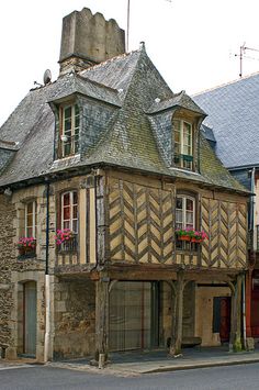 an old building with flowers in the window boxes