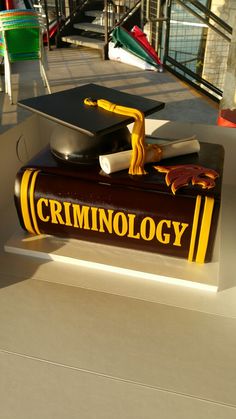 a graduation cake made to look like a book with the words criminology on it