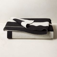 black and white striped blanket folded on top of each other in front of a wall