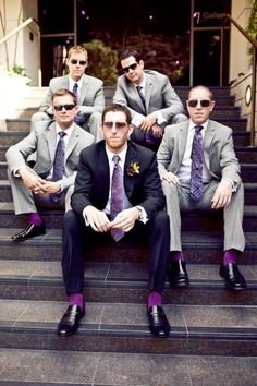 a group of men in suits and ties sitting on steps with one man wearing sunglasses