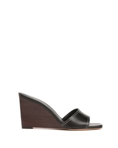 Timeless, understated, chic—the Ellen sandal is a peep-toe mule with a stacked wooden wedge heel. Crafted from smooth leather with contrast stitching, it has an on-trend Nineties feel. The cushioned footbed and slip-on style ensure easy wear, and the polished silhouette pairs well with dresses and jeans alike.Leather 3.25” heel Store in a cool, dry place inside dust bag Clean under the supervision of a specialist Style # J0044L1 Summer Workwear Calf Leather Mules, Calf Leather Wedge Heel Sandals, Calf Leather Wedge Sandals, Leather Wedge Heel Sandals For Work, Leather Wedge Mules With 4-inch Heel, Spring Wedge Heels In Calf Leather, Leather Lined Wedge Sandals, Spring Calf Leather Wedge Heels, Calf Leather Wedge Heels For Spring