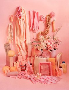 an image of a pink room with clothes and flowers on the wall, next to other items