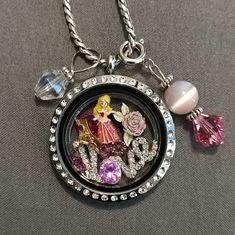 Pre-Owned. Origami Owl Disney Aurora Sleeping Beauty Locket Set. Excellent Used Condition. The Charms Are Brand New. Origami Owl Large Hinged Silver Locket With Crystals, Origami Owl Silver Necklace, Origami Owl Crystal Love Insert, Origami Owl Aurora, Crown & Rose Charms And Six Pink Crystals. **2 Free Dangle Charms- Includes An Iridescent Clear Bead And Pink Beads Silver Dangle Charms To Put On Necklace. The Dangle Charms Are Not Origami Owl. As Pictured.** #A330 Disney Sterling Silver Jewelry In Silver, Disney Silver Jewelry For Birthday, Disney Silver Jewelry For Anniversary, Pink Disney Jewelry For Gift, Pink Disney Jewelry For Gifts, Disney Style Pink Jewelry Gift, Personalized Disney Silver Jewelry, Whimsical Silver Charm Necklace For Birthday, Themed Silver Necklace For Birthday