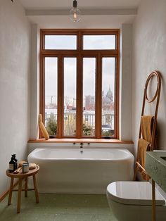 a bath tub sitting next to a window in a bathroom