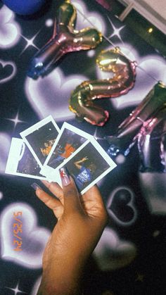 a person holding up some cards in front of balloons