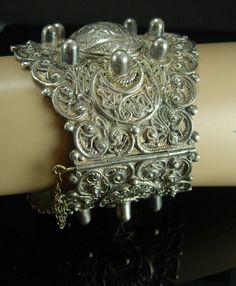 "This over the top Turkish bracelet is a whopping 2 3/4\"' wide and is one of the most fabulous detailed bracelets I have seen. Hand wrought and made with layers of etruscan work, this bracelet is a true attention getter. It has two panels with ornate designs so you can see them from every angle when you wear this. It has a slide in pin closure which works great. It has not been polished so it retains some of its patina. VERY heavy and well made. When closed it is 7 1/2\". It is a very impressiv Antique Silver Adjustable Cuff Bracelet With Intricate Design, Ornate Adjustable Silver Cuff Bracelet, Handmade Sterling Silver Ornate Cuff Bracelet, Turkish Bracelet, Ornate Handmade Cuff Bracelet Collectible, Ornate Handmade Antique Silver Cuff Bracelet, Boys Necklace, Baroque Frames, Wedding Bottles