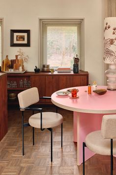 a pink table with four chairs around it