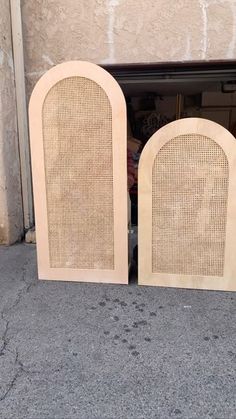 two wooden speakers sitting next to each other on the ground in front of a building