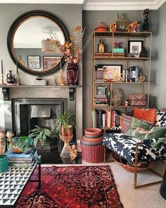 a living room filled with furniture and a fire place under a mirror on the wall