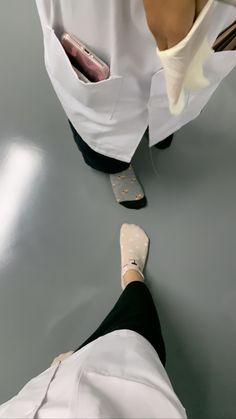 two people in white lab coats and black pants