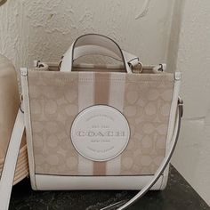 Coach Tote Bag In Great Used Condition Has Some Minor Wear On The Bottom ( Second Picture) But Can Be Cleaned Detachable Strap Measurements: Length: 8.75" Height: 6.25" Width: 4.25" Coach Beige Rectangular Bag, Coach Beige Shoulder Bag With Dust Bag, Beige Coach Shoulder Bag With Dust Bag, Chic Cream Coach Shoulder Bag, Beige Coach Bag With Detachable Strap, Chic Beige Coach Shoulder Bag, Coach Beige Tote Bag, Coach Double Handle Canvas Bag, Chic Cream Coach Bag