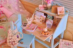 a doll house with furniture and accessories on the floor, including a desk and chair