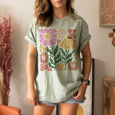 This cute shirt features retro flowers. This will become your new favorite shirt that you reach for again and again. Makes a great gift for anyone who loves cottagecore fashion. * Q U I C K * F A C T S * ♥ 100% cotton medium weight shirt ♥ Design is high quality digital print ♥ Wash and dry normally (on cool for best results) * S I Z I N G * ♥ Sizing is unisex so runs like men's ♥ Relaxed fit shirt ♥ Please see size guide in listing photos for all measurements and information * S H I P P I N G * Cottage Core Shirt, Wildflower Shirt, Cottagecore Shirt, Botanical Shirt, Cottagecore Fashion, Shirt Design Inspiration, Flower Shirt, Wild Flower, Retro Flowers