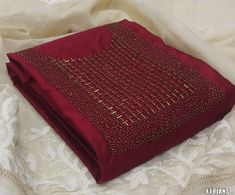 a close up of a piece of cloth on a lace tablecloth with gold stitching