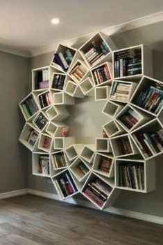 a circular book shelf with books on it in the middle of a room filled with hardwood floors