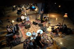 a group of people sitting on top of a wooden floor in front of musical instruments