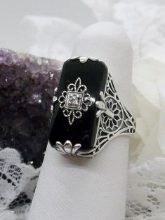 Black Camphor Glass Ring with White CZ inset Elegant Black Jewelry With Intricate Design, Ornate Black Sterling Silver Rings, Ornate Black Rings For Gifts, Ornate Black Rings As Gift, Ornate Black Rings For Gift, Ornate Black Filigree Jewelry, Elegant Black Enamel Jewelry For Wedding, Vintage Black Oval Filigree Ring, Black Victorian Rings With Black Enamel