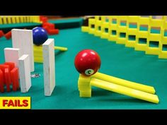 a close up of a toy ball and some fence posts on a play ground with other toys in the background