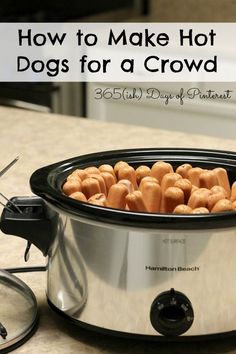 a crock pot filled with hot dogs sitting on top of a counter